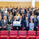 Gruppenbild mit rund 80 Wissenschaftlerinnen und Wissenschaftlern in einem Hörsaal. 