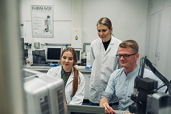 Menschen im Labor untersuchen ein Gerät 