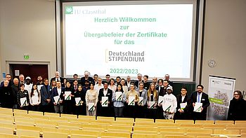 Übergabezeremonie des Deutschlandstipendiums mit Studierenden, die ihre Zertifikate in einem Hörsaal halten