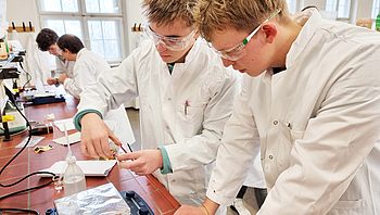 Zwei Studenten führen in einem Labor ein Experiment durch