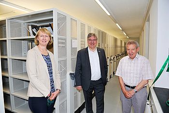 Drei Menschen stehen im Archiv der TU Clausthal