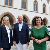 Zwei Frauen und ein Mann stehen vor dem historischen Rathaus der Stadt Goslar.