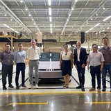 Eine Gruppe besucht eine Ausstellungshalle eines Autoherstellers. 